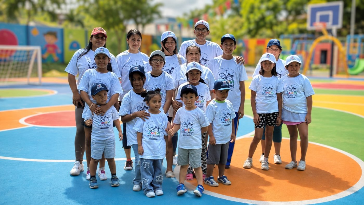 Volunteers and children in white shirts at a community event